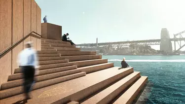 Two people standing and two people sitting on the steps of the Opera House by the water's edge