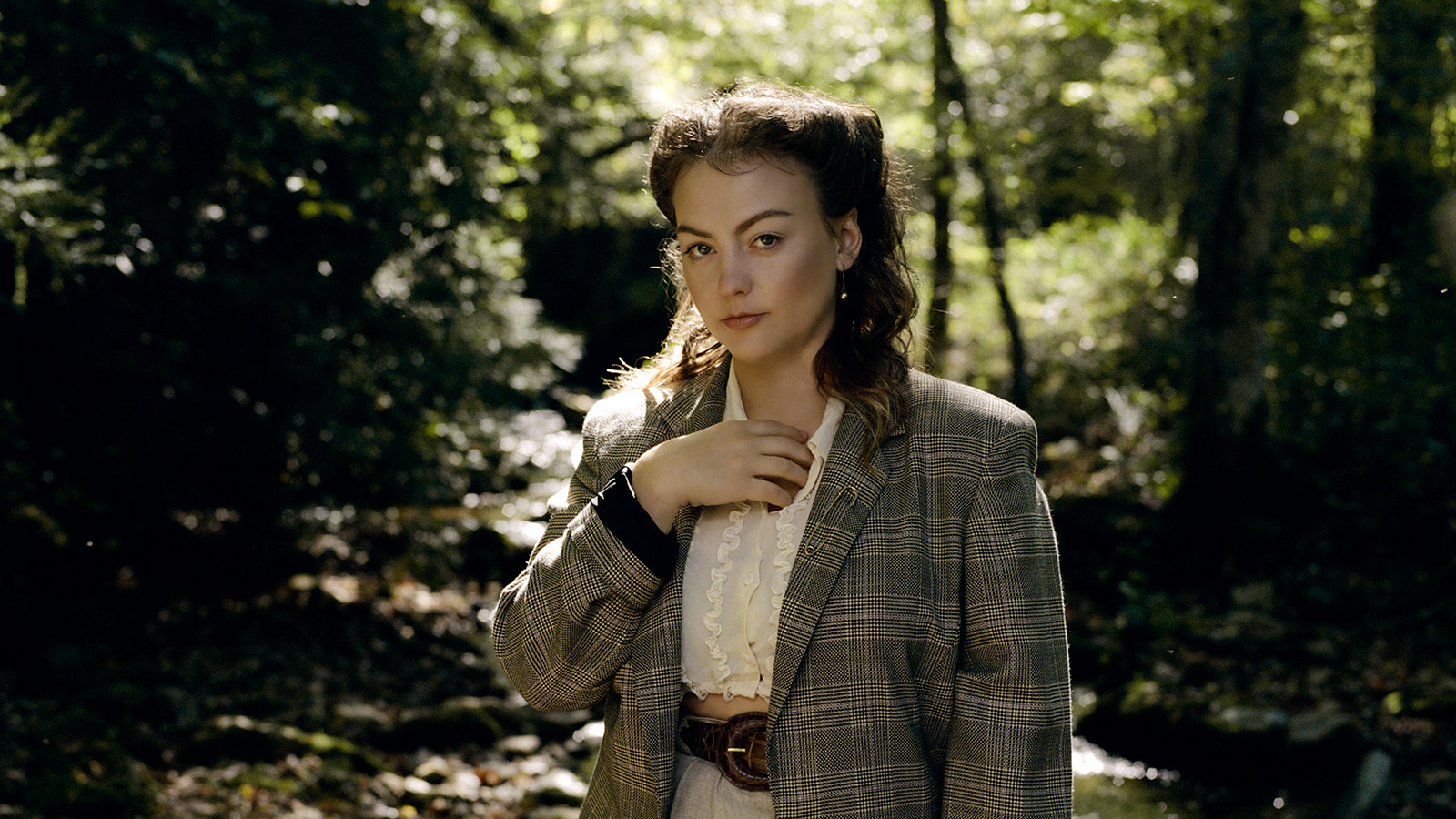 American singer-songwriter Angel Olsen standing near a river bed.