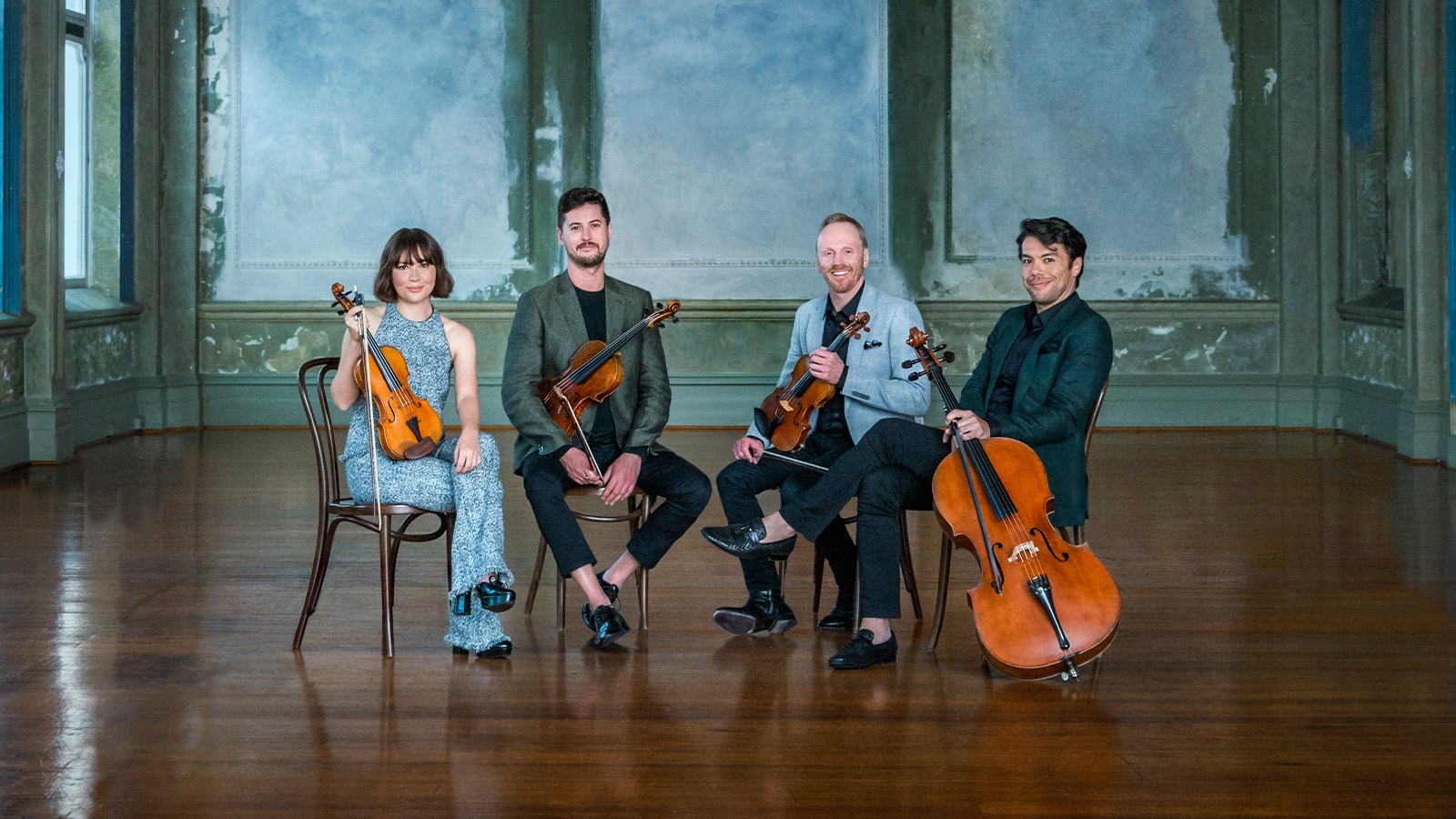 A group of string ensemble sitting on the chair.