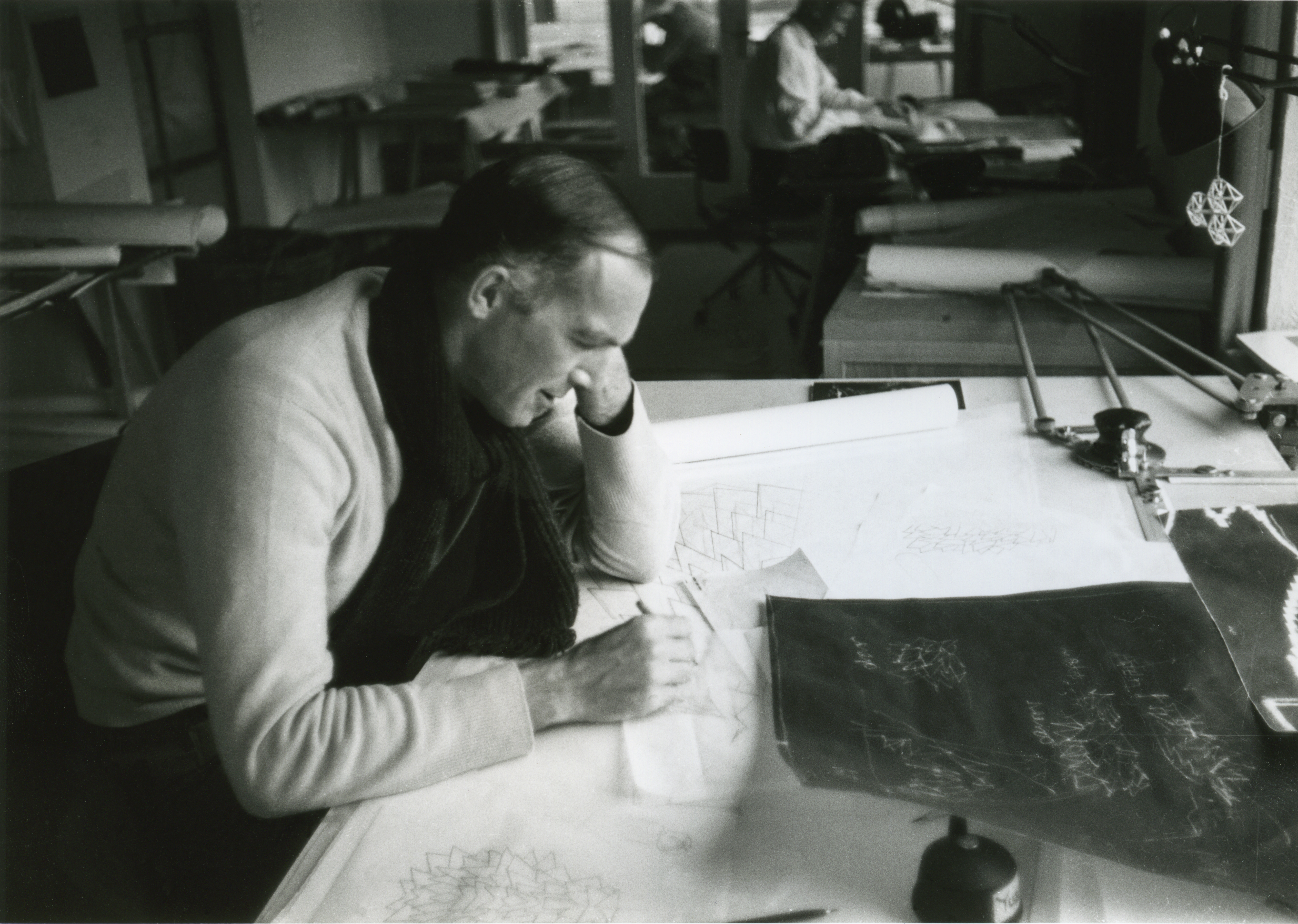 A Danish architect drawing on a drafting table.