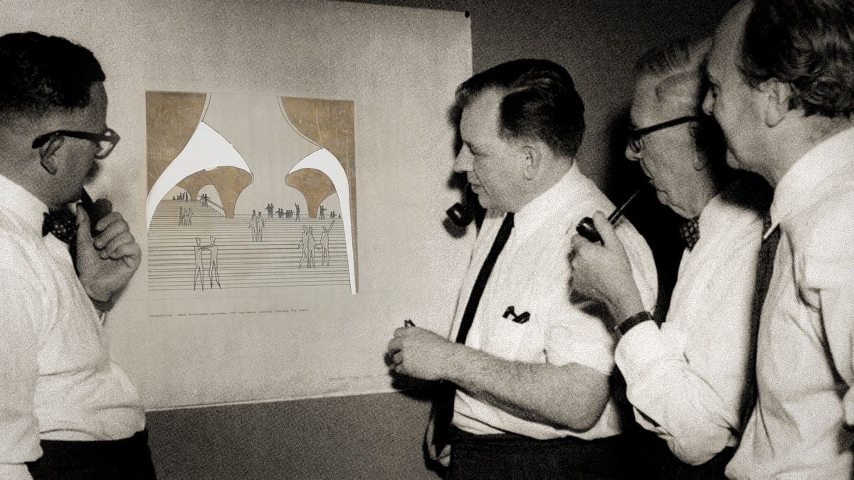 Four men looking at a drawing.