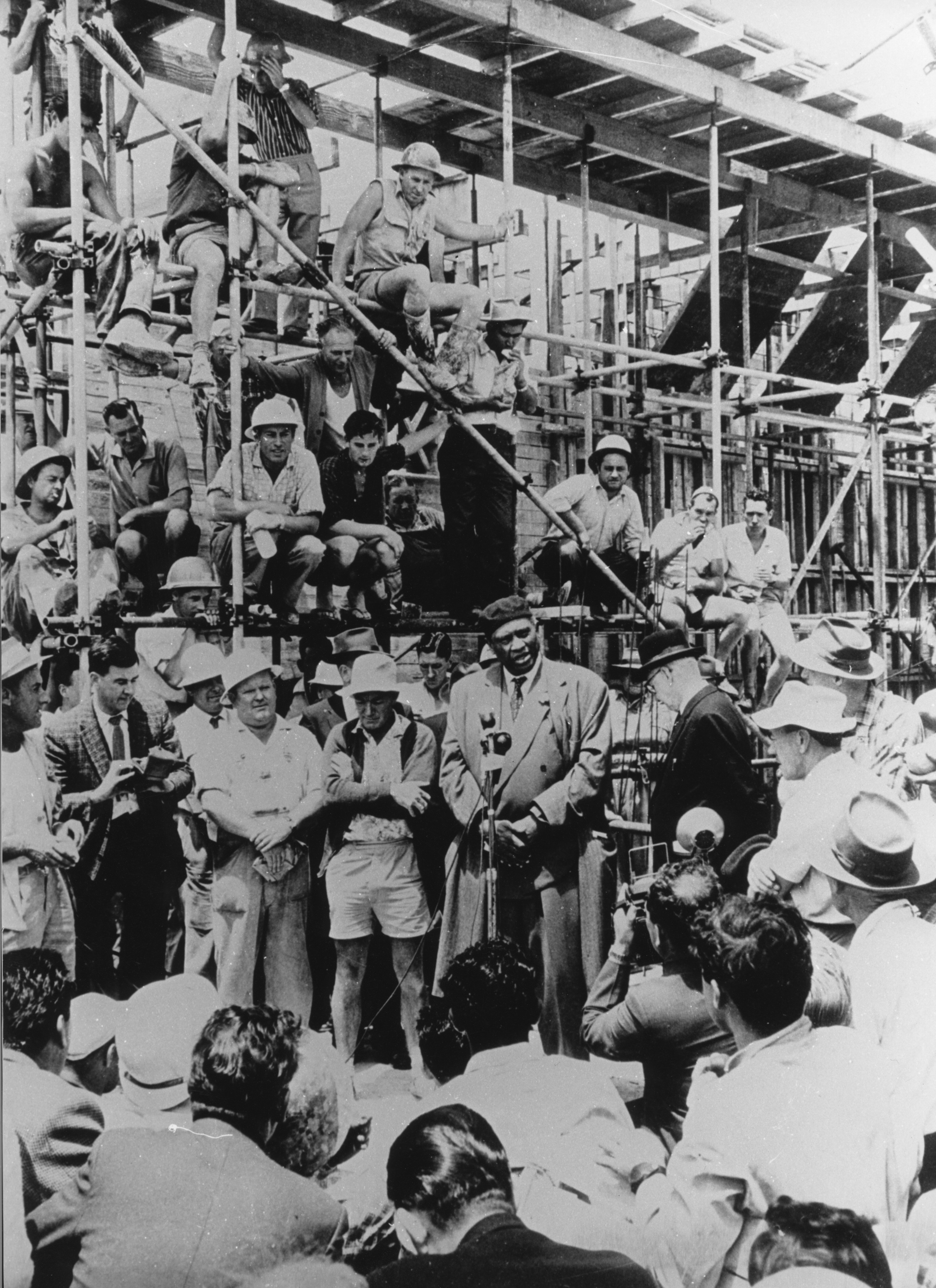 A crowd of people listening to a man giving speech.