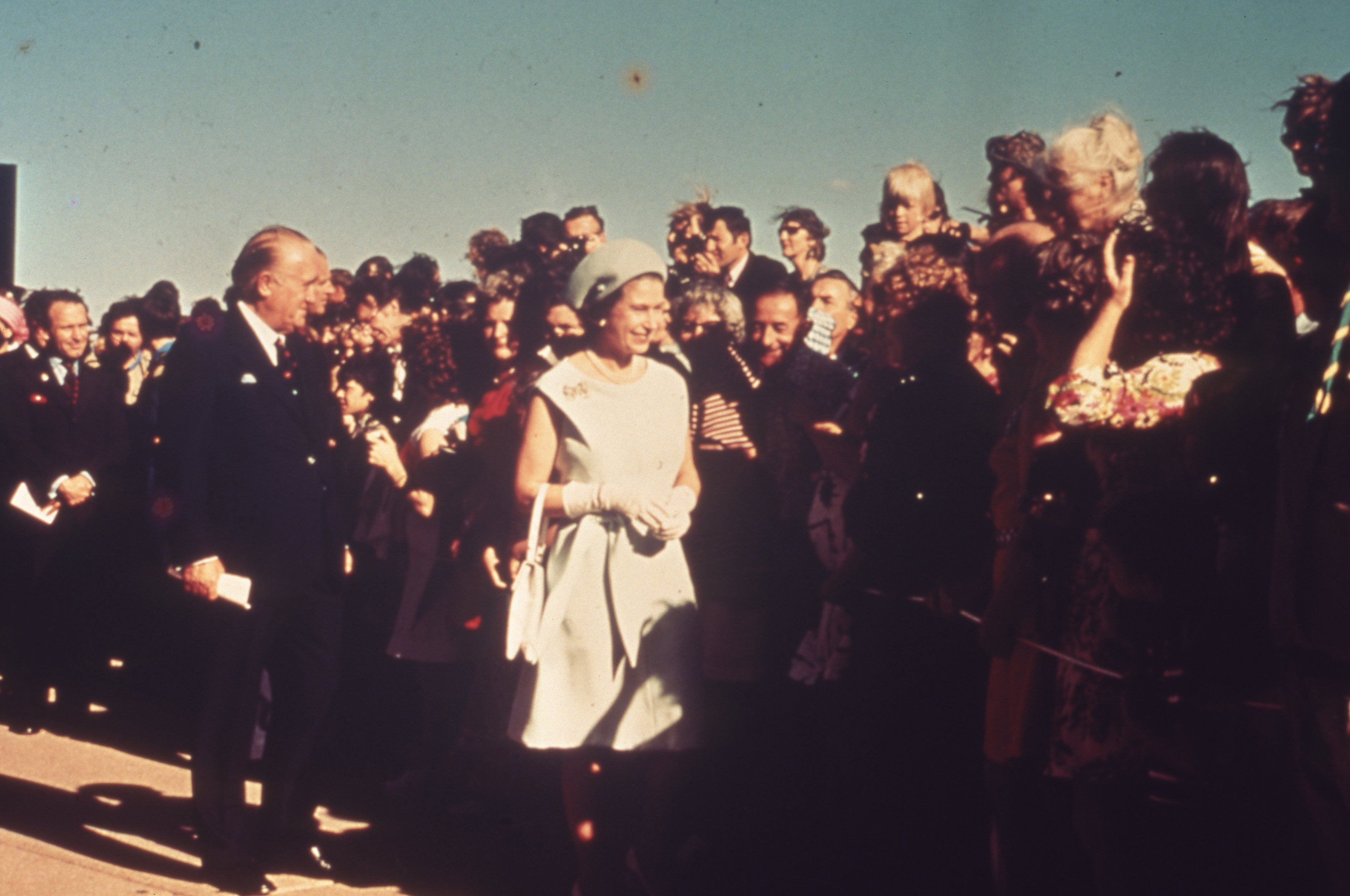Queen Elizabeth II walking by the crowd of people.