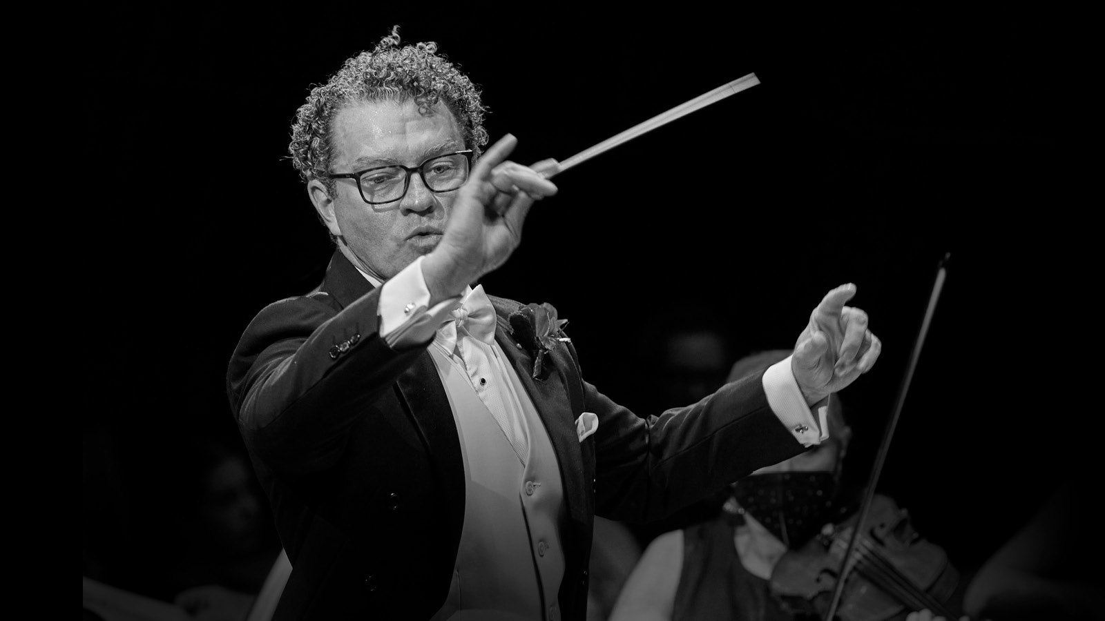 An orchestra conductor waving a baton.