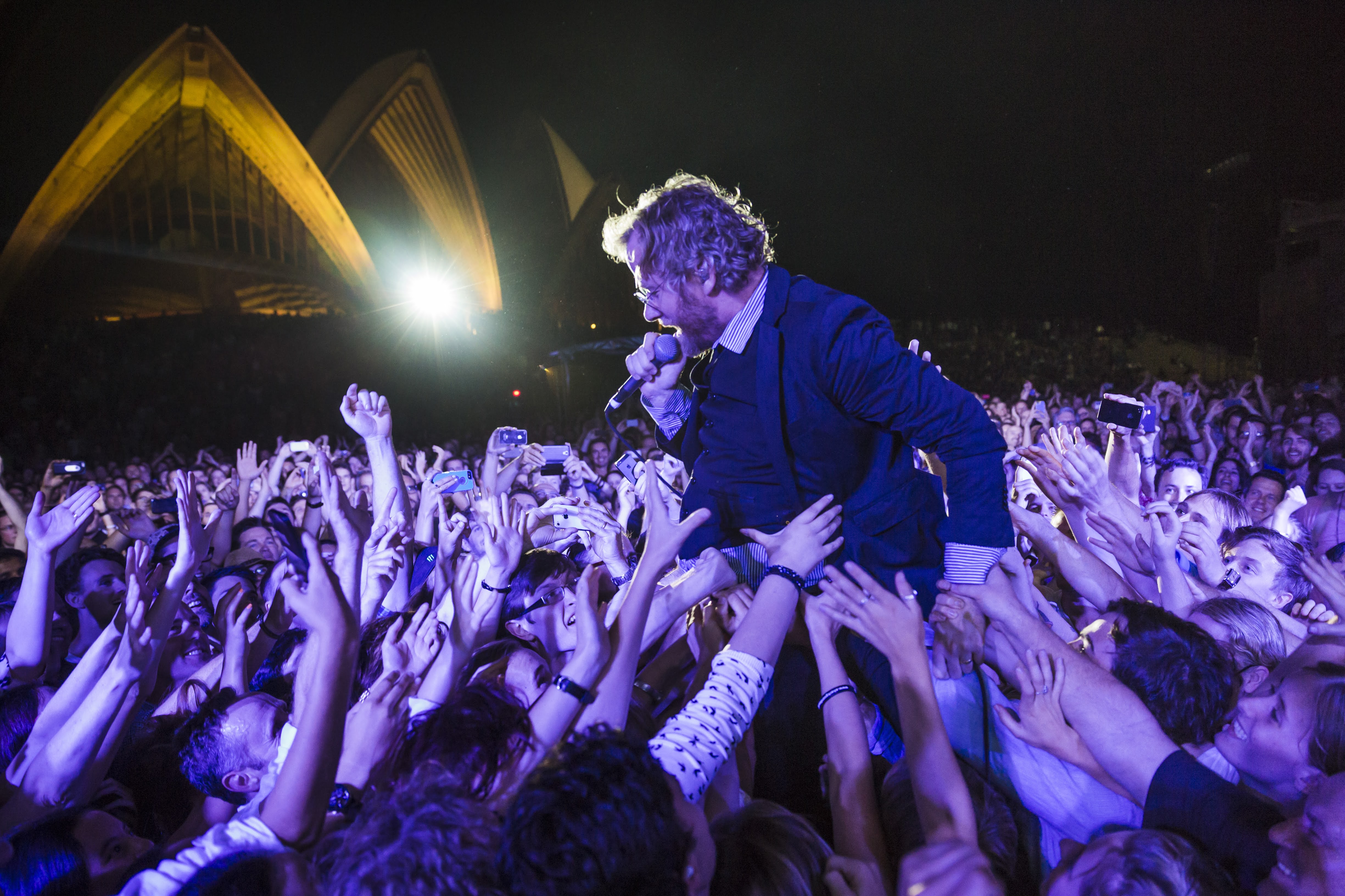 A man singing as the crowd lifts him up.