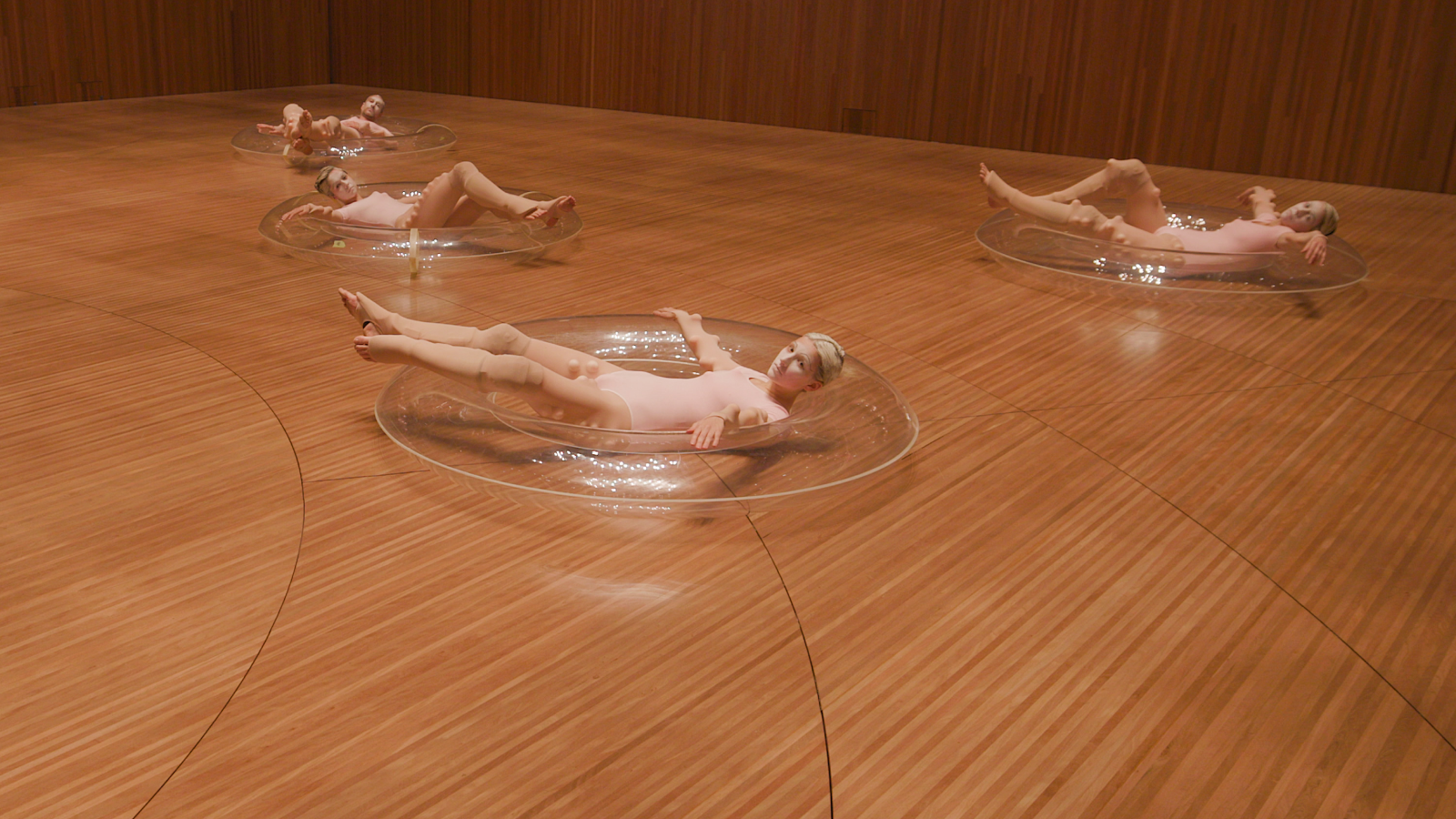 A dance group lying on the acoustic doughnuts.