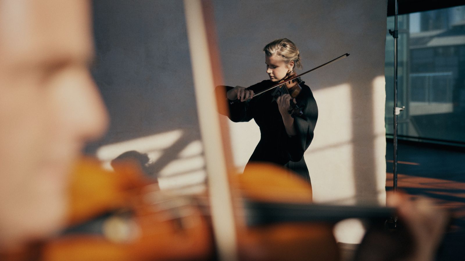 A blonde woman playing a violin.