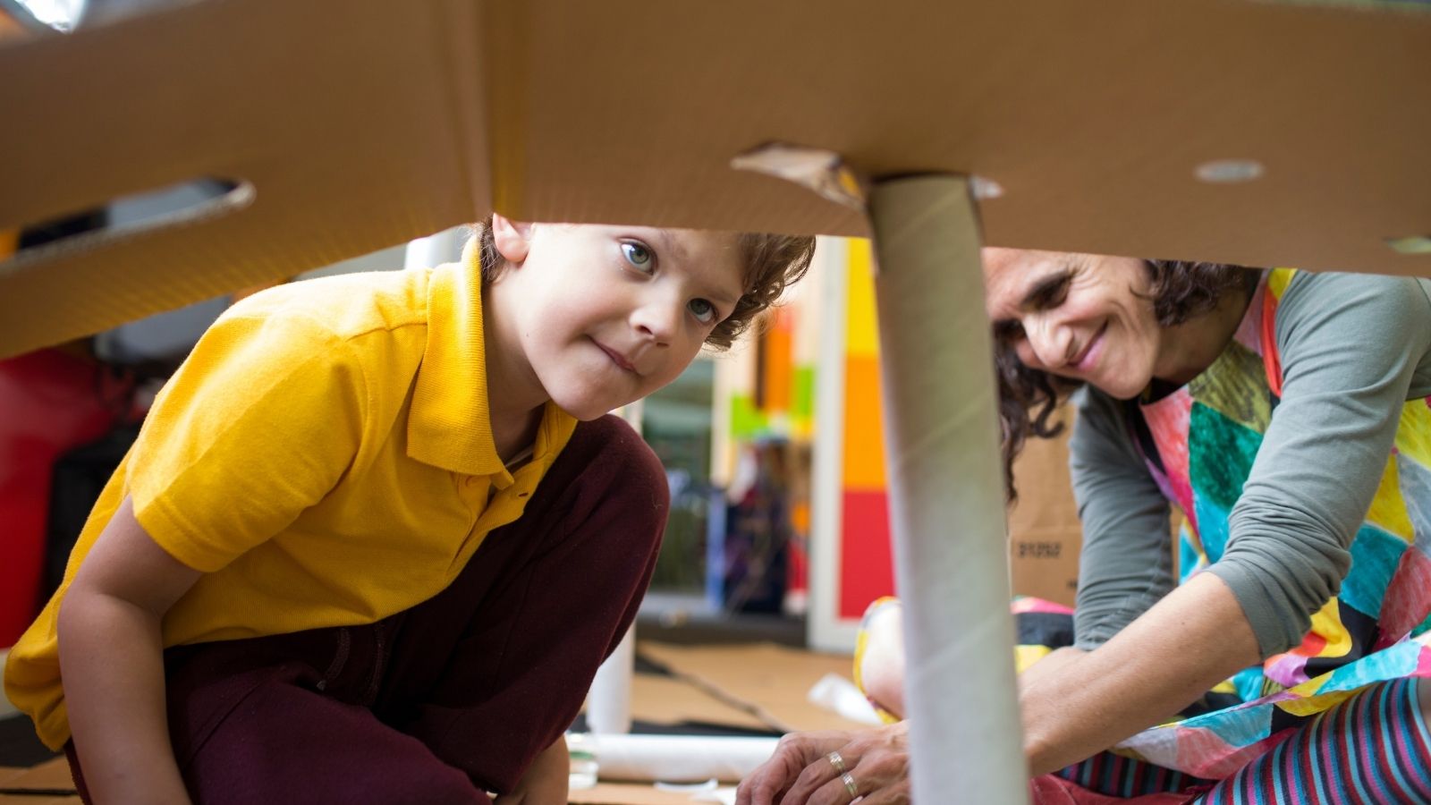 Educators and the kids playing with cardboard.