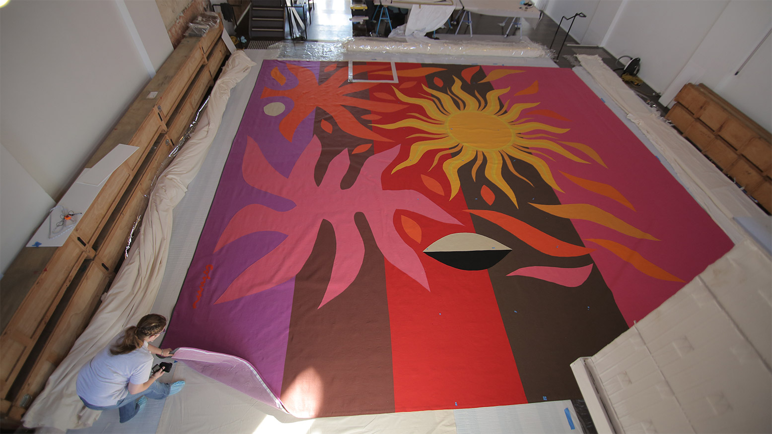 A women assessing the Tapestry cloth in a warehouse.