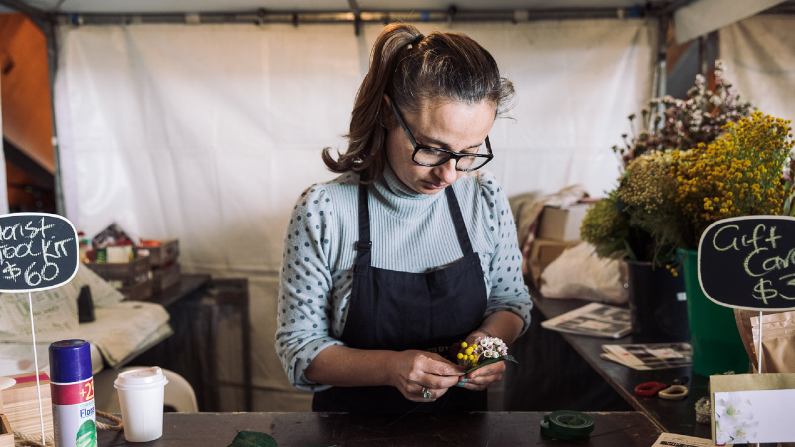 A woman in a flower shop wearing an apron.