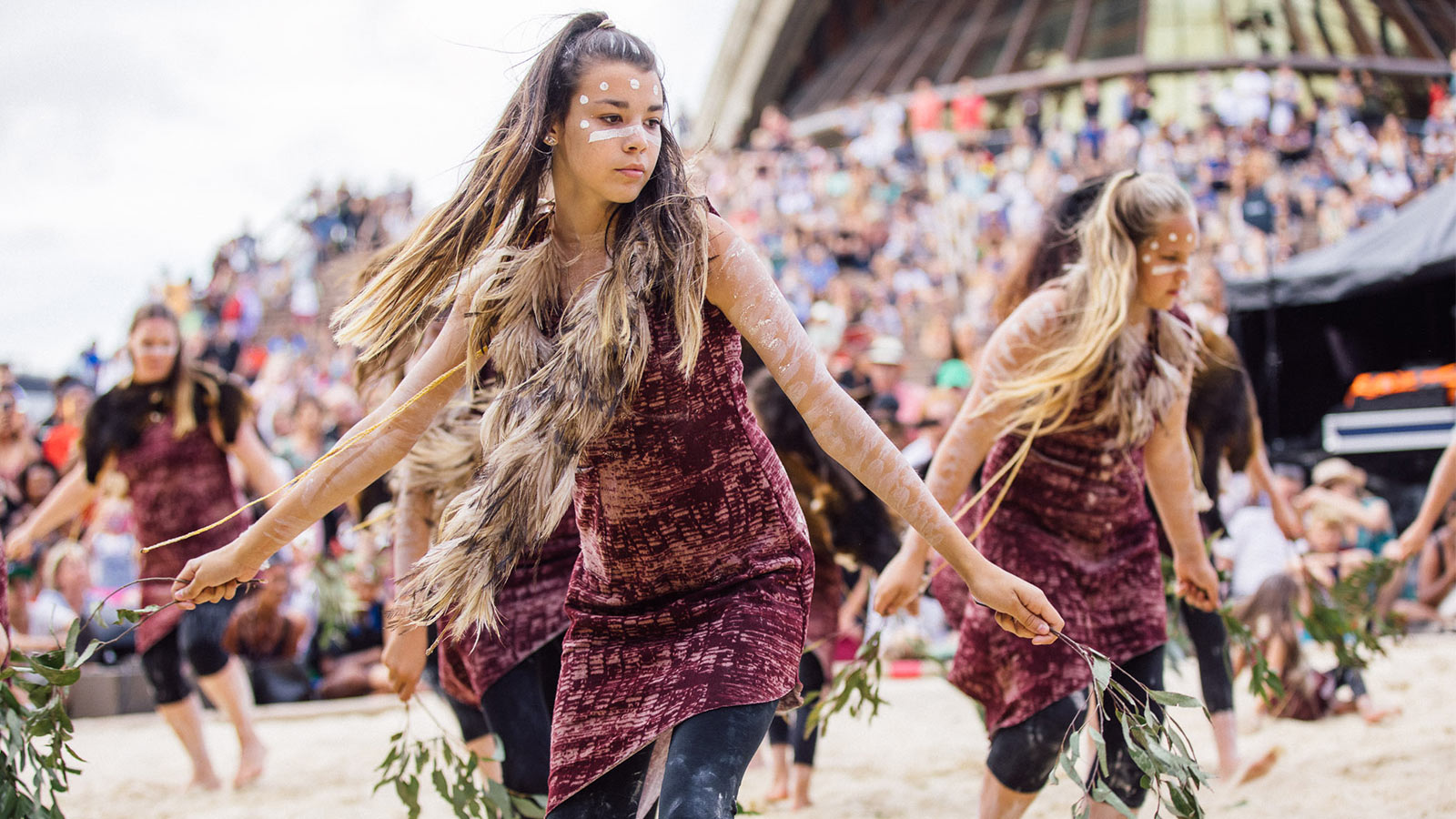 Women performing indigenous dance in the homeground of Sydney opera house.