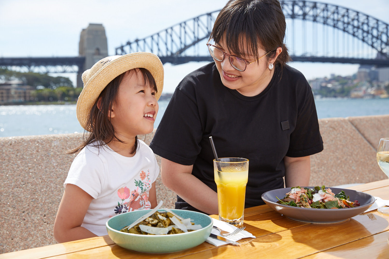 A woman and a girl having food at Opera bar.