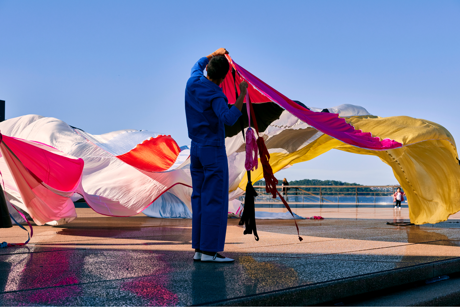 A man holding a long colourful curtain.