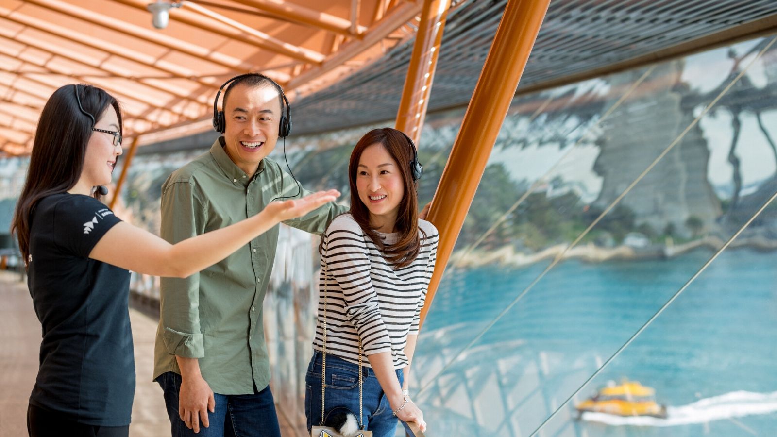 A couple with a tour guide looking at the Harbour view from the Sydney opera house.