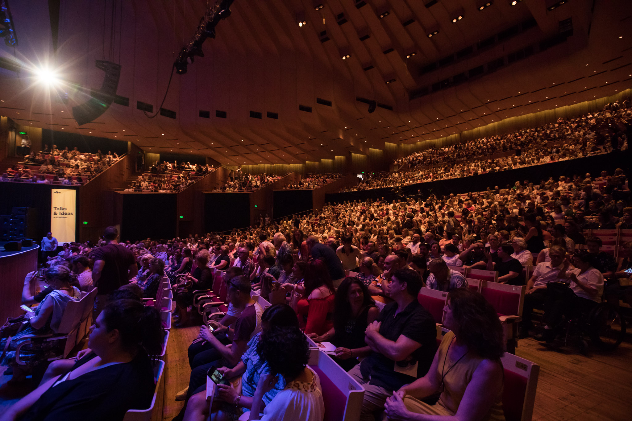 Rows of seated audience in a huge theatre.