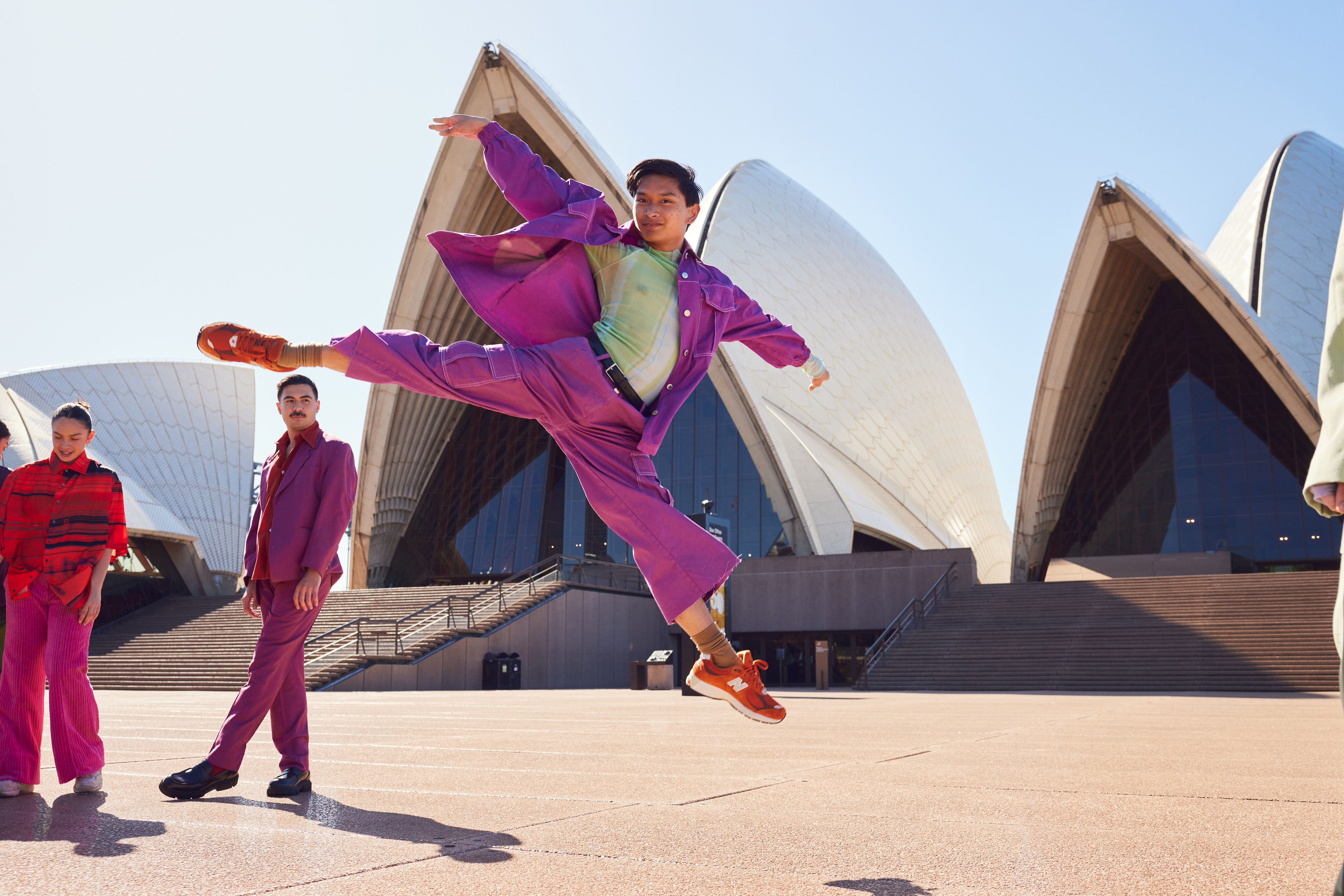 A dancer leaps in the air with the Sydney Opera House in the background.