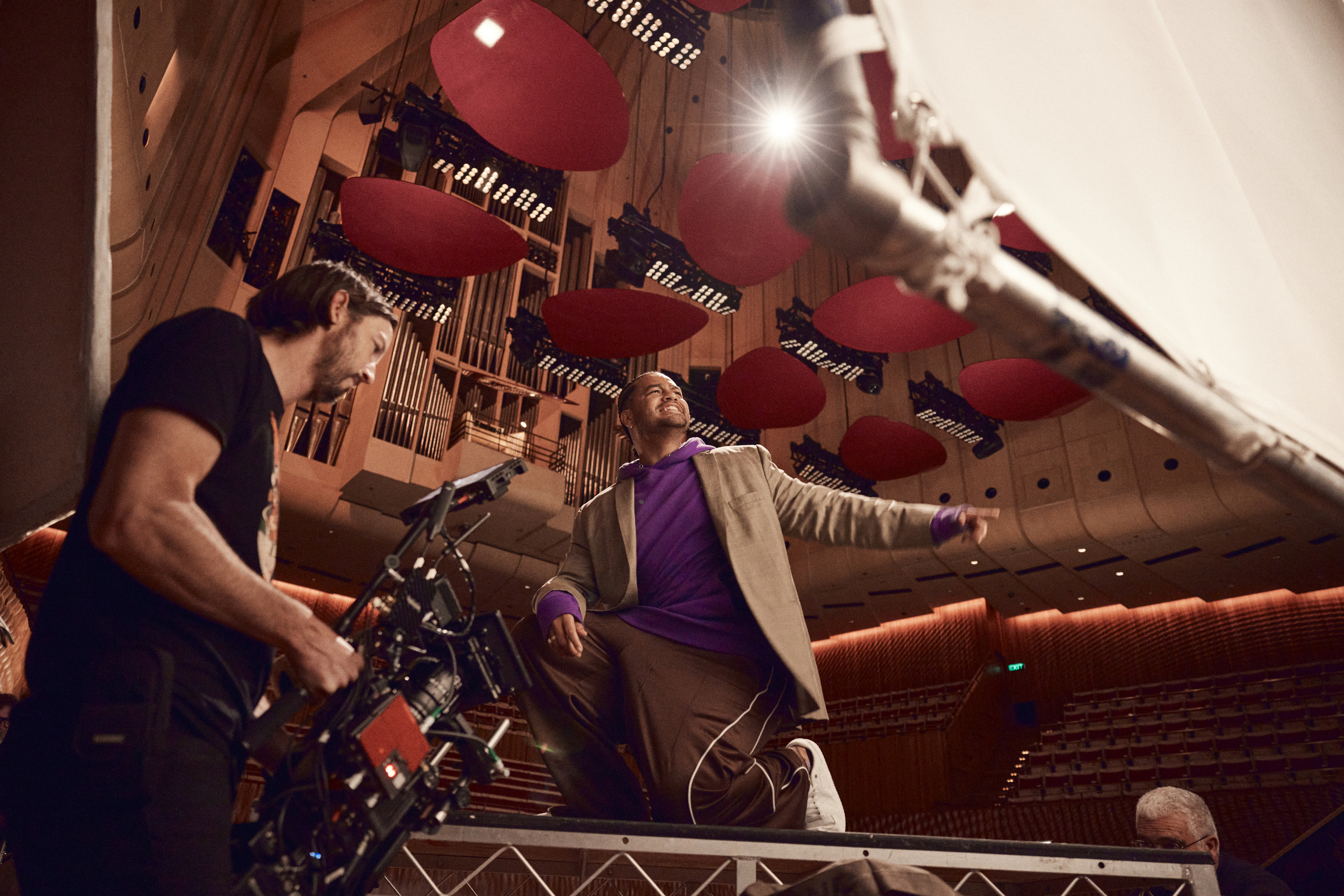Ziggy Ramo and a cameraman standing inside Sydney Opera House.