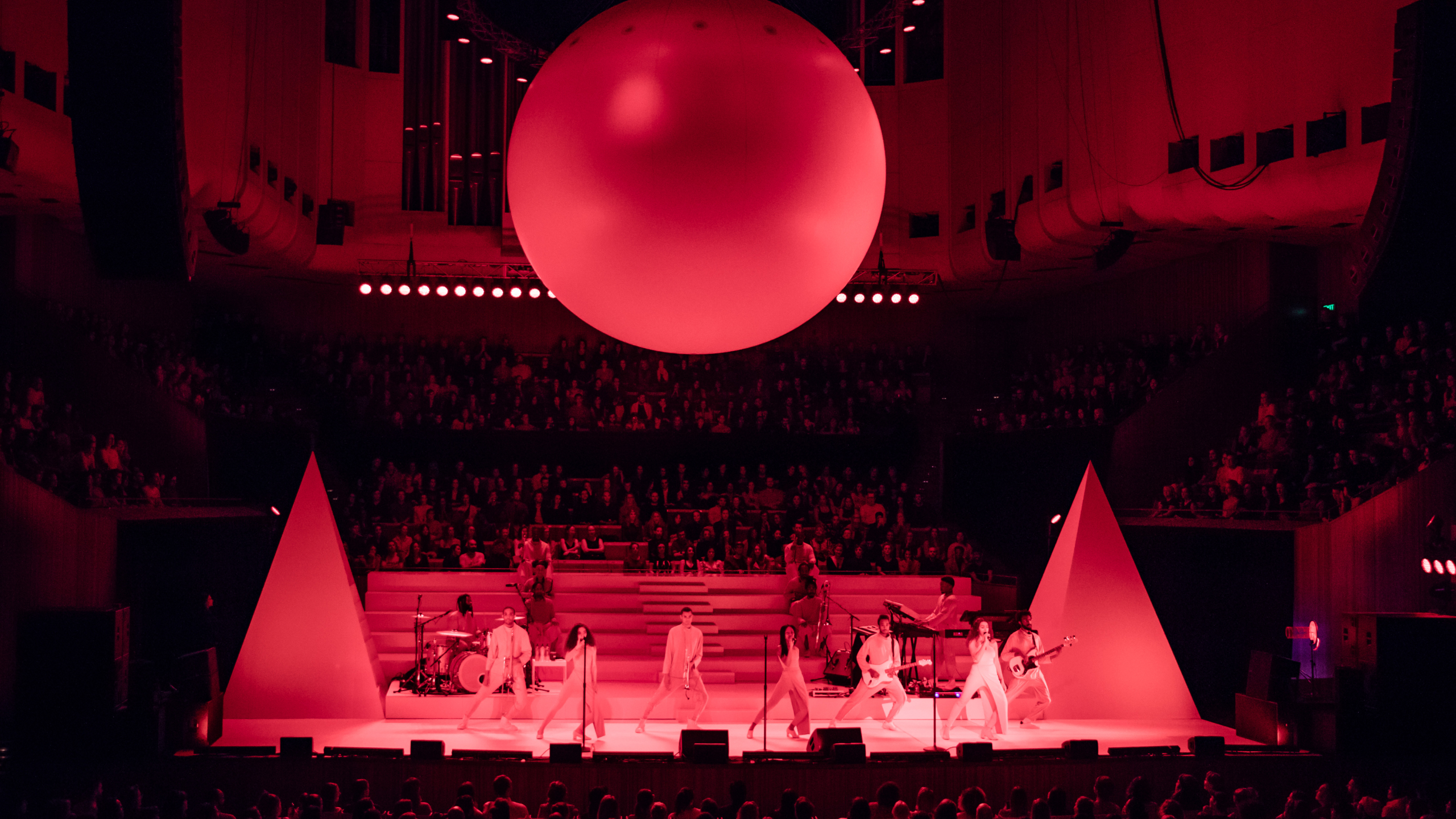 A group of musicians performing on the stage with a big balloon above them.