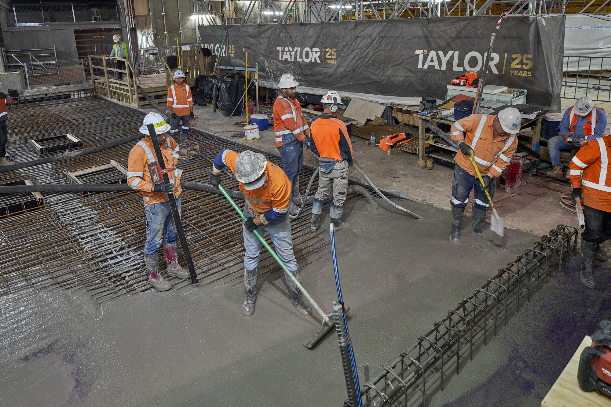 Construction workers pouring concrete into the new steel frame of the stage.