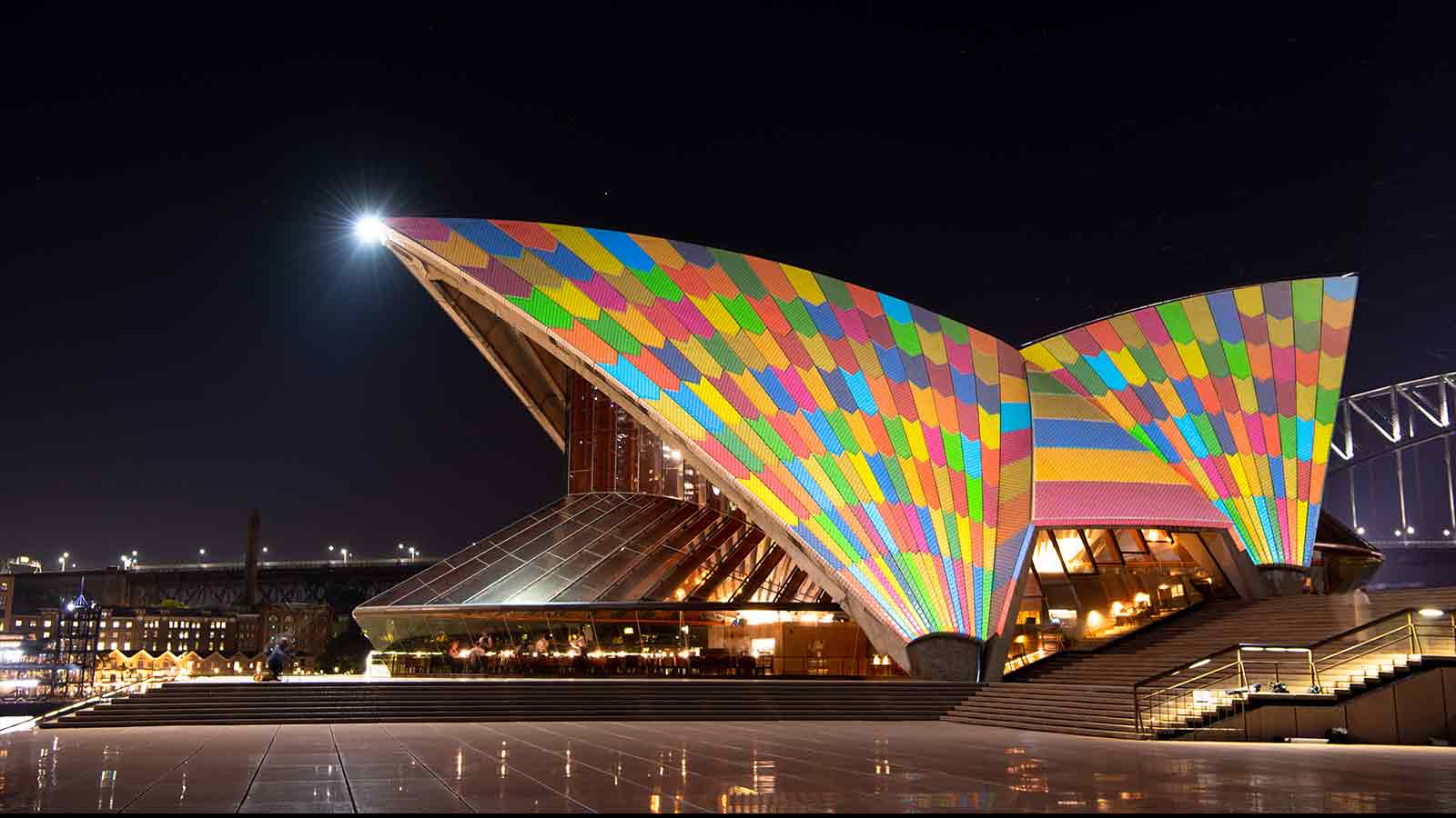 The Sydney Opera House's sails illuminated by colorful squares.