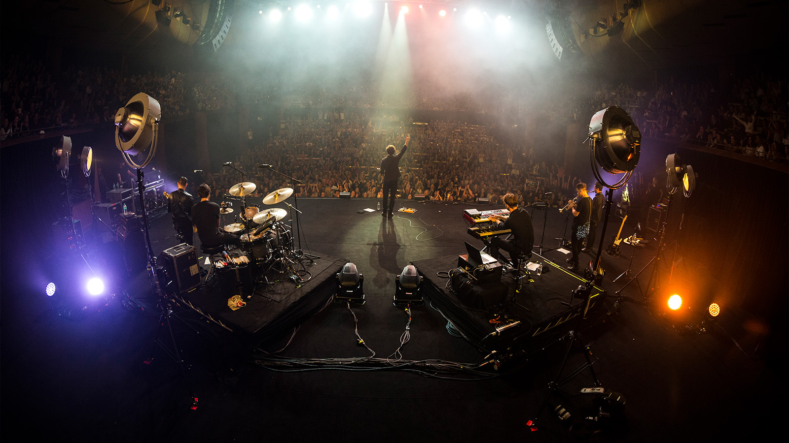 An Australian singer Vance Joy performing on the stage with his band.