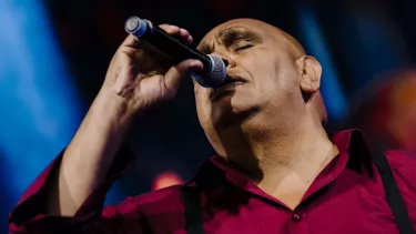Kutcha Edwards sings with microphone in hand