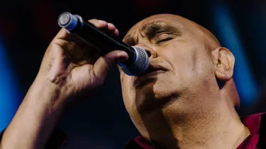 Kutcha Edwards sings with microphone in hand