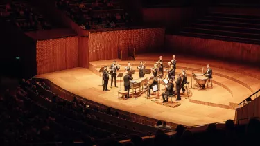 A small chamber orchestra with Harpsichord stand at the Sydney Opera House concert hall