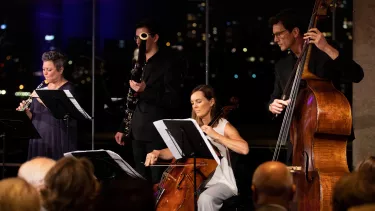 A horn, bassoon, cello, and double bass musician play in the Utzon Room