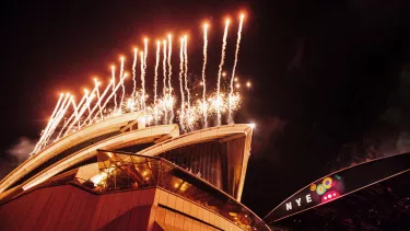 Fireworks are going off above the Sydney Opera House sails.