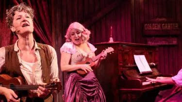Calamity Jane on Stage with a guitar