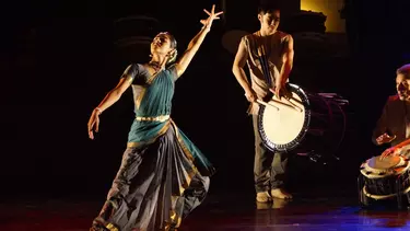 A woman in an Indian saree dancing to the sound of a Japanese drum