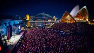 Concertgoers at a show in front of the Sydney Opera House.