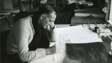 A Danish architect drawing on a drafting table.
