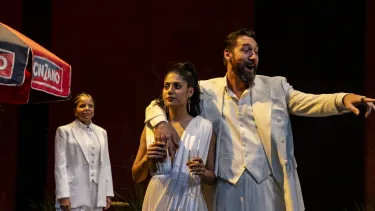 A man stands with his arm wrapped around a woman pointing