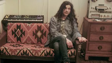 Kurt Vile an American singer sitting in his studio.