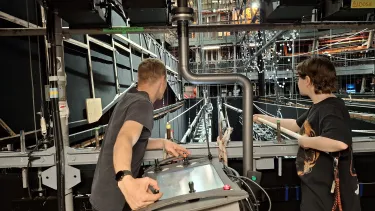 Two stage techinicians stand backstage