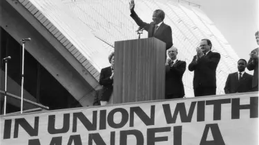 A man standing on a podium, waving his hand.