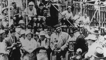 A crowd of people listening to a man giving speech.