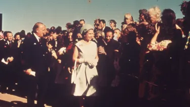 Queen Elizabeth II walking by the crowd of people.