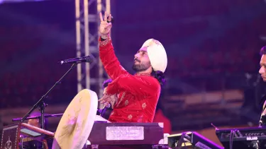 A man in a turban holds a microphone