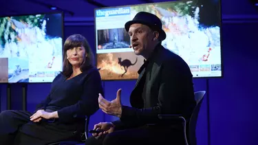 A man and a woman sitting on a chair in a talk show.