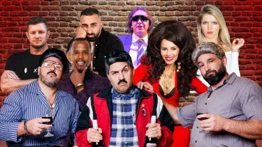 A group of seven men and two women pose in front of a brick wall.
