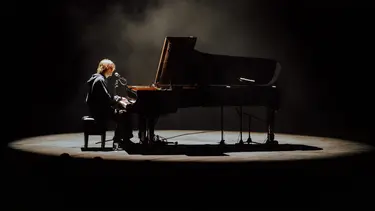 Cameron Winter sits at a grand piano.