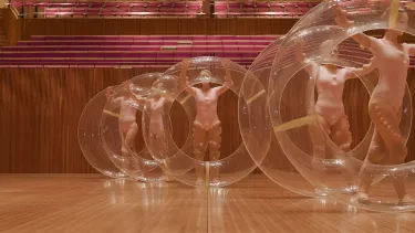 Dance group holding the acoustic doughnuts.