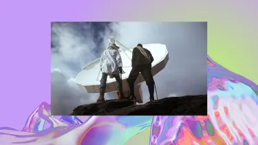 Two people standing on a rock looking up at a satellite dish.