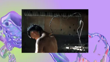 A person is standing with their head down. They have an outlet with wires connected on their upper back.