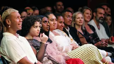 A crowd of people sitting on the chairs.