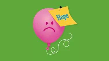 A pink balloon with a sad face on it has a post it note saying 'hope' pinned into it.