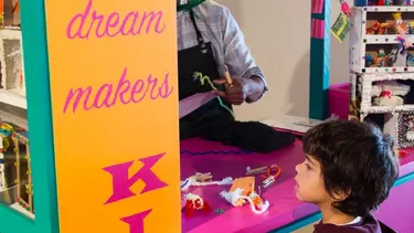 A kid getting a temporary tattoo from a stall.